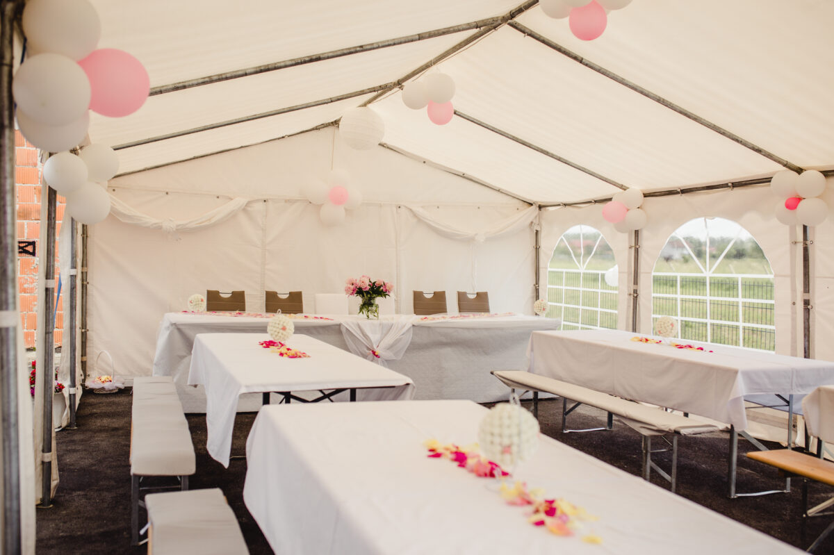 The,Tables,And,Benches,In,A,Wedding,Tent,Decorated,With