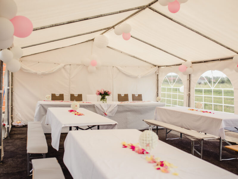 The,Tables,And,Benches,In,A,Wedding,Tent,Decorated,With