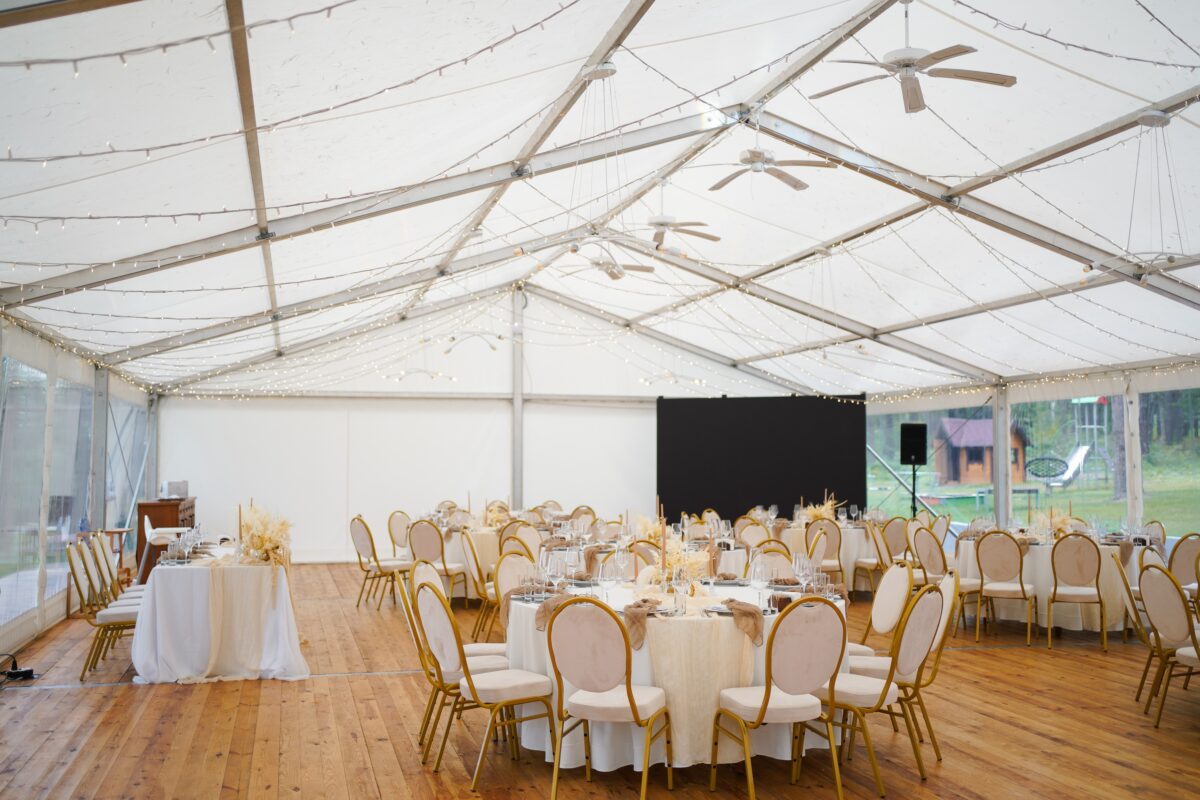 Wedding,Marquee,With,Round,Tables,,Chairs,And,Decor,In,Light