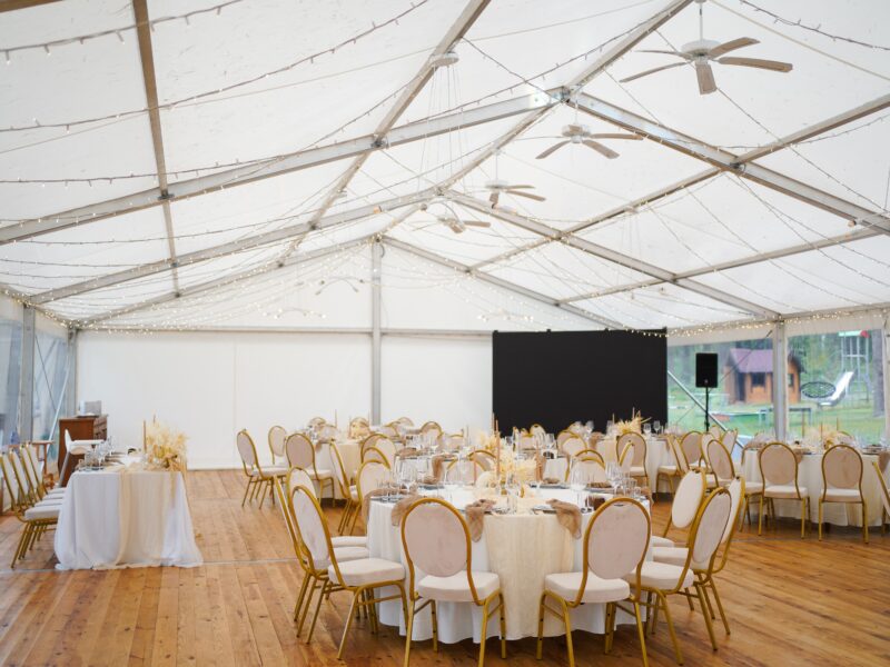 Wedding,Marquee,With,Round,Tables,,Chairs,And,Decor,In,Light
